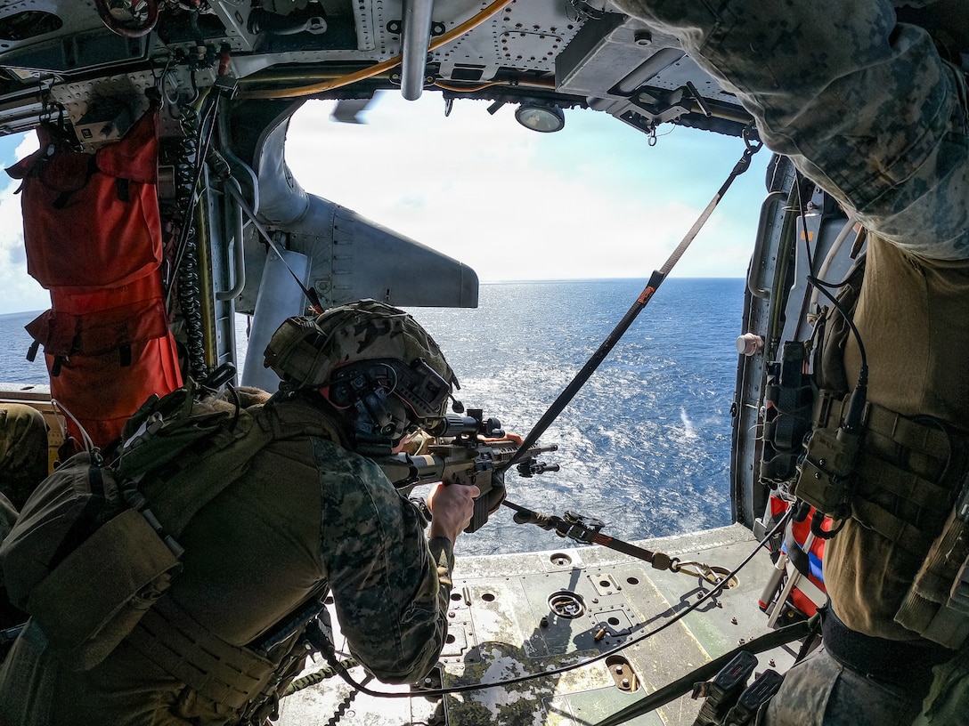 A U.S. Marine with Maritime Special Purpose Force, 22nd Marine Expeditionary Unit (Special Operations Capable), fires at a target with a M110 semi-automatic sniper system aboard a MH-60S Sea Hawk helicopter assigned to Helicopter Sea Combat Squadron (HSC) 26, during aerial sniper training while underway in the Caribbean Sea, Feb. 3, 2026. U.S. military forces are deployed to the Caribbean in support of the U.S. Southern Command mission, Department of War-directed operations, and the president’s priorities to disrupt illicit drug trafficking and protect the homeland. (U.S. Marine Corps photo)