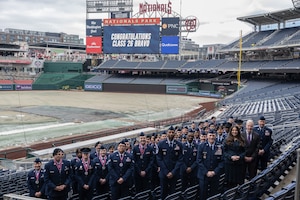 A group poses for a photo in the stands of a baseball stadium.