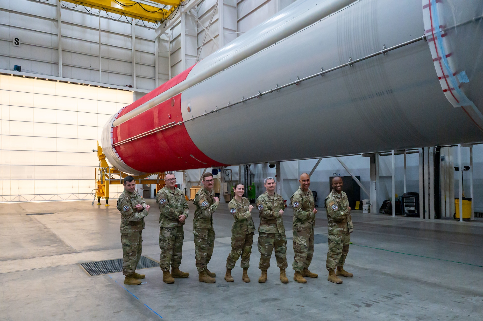 People pose for a photo in a large room.