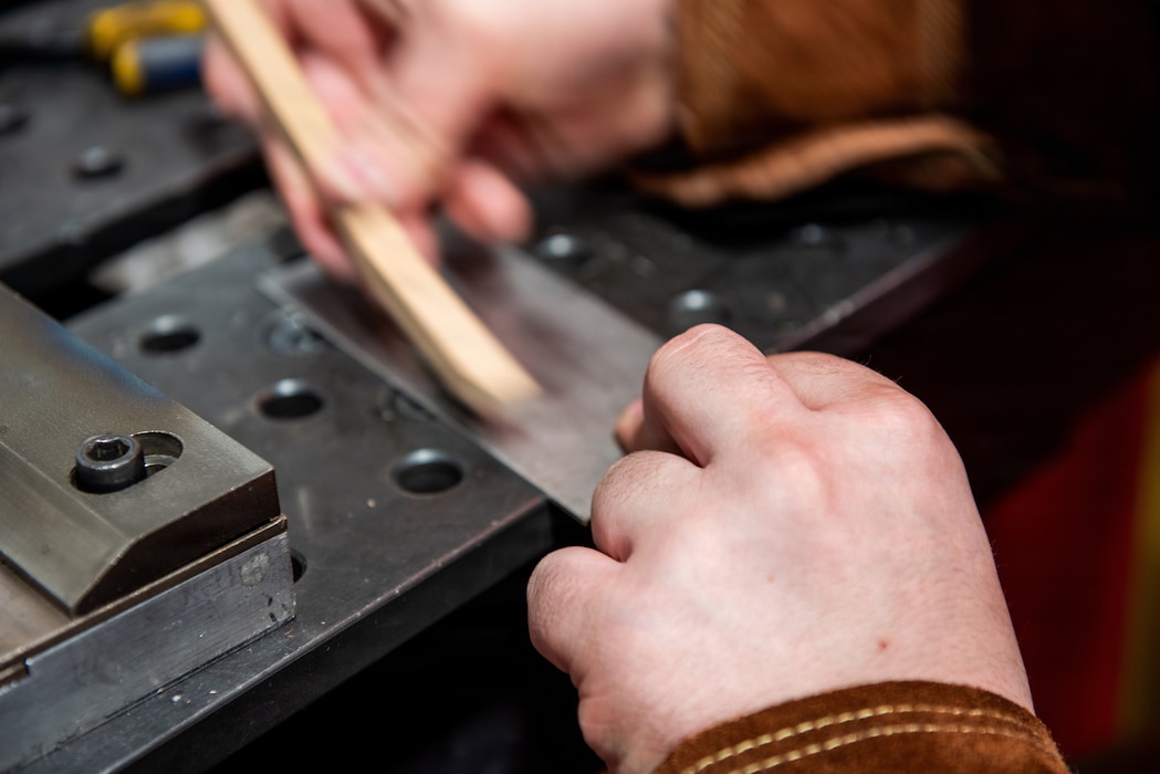 Airman cleans workspace
