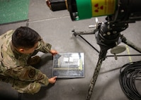 An Airman lays a test plate on top of a blank sheet of X-ray film.