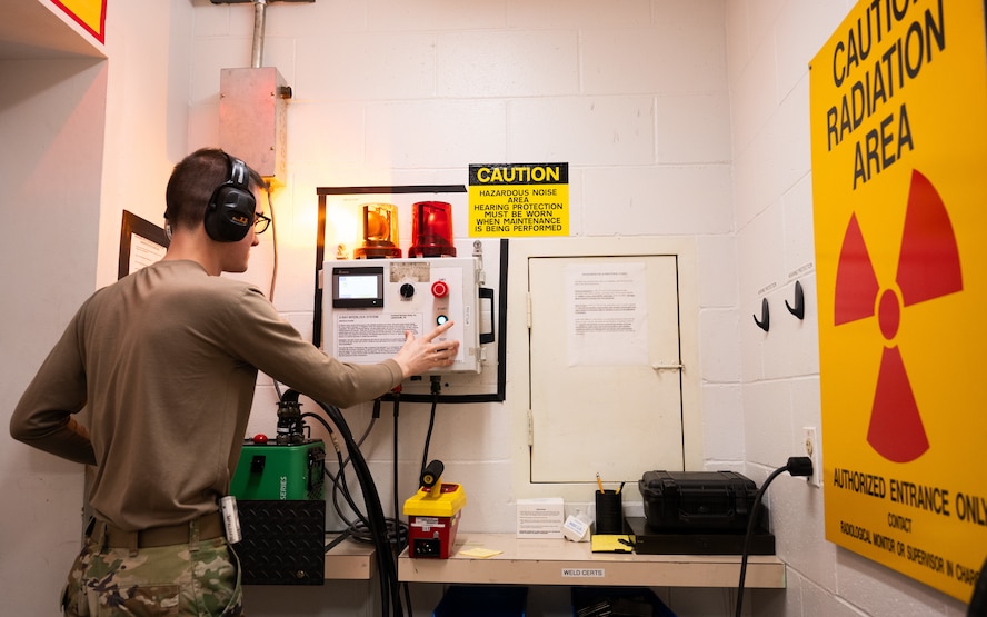 An Airman presses a button to simulate activating an X-ray system.
