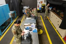 Airmen work on various nondestructive inspection tasks inside their workshop.