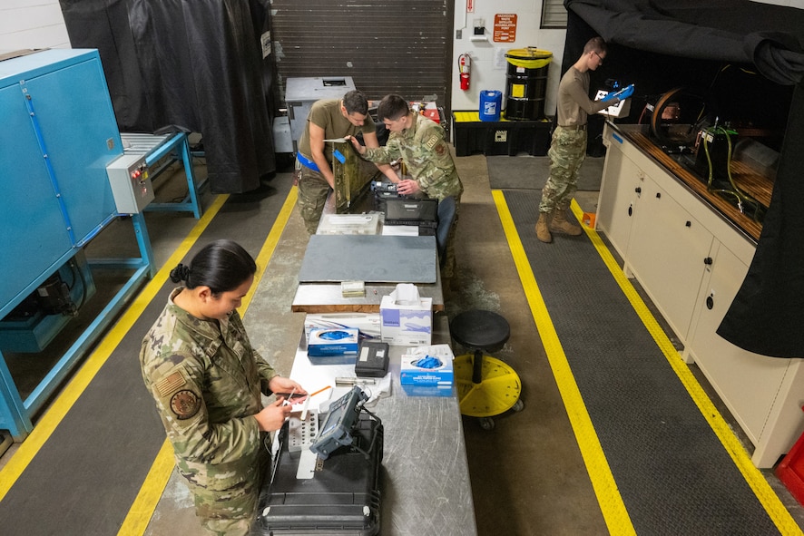 Airmen work on various nondestructive inspection tasks inside their workshop.