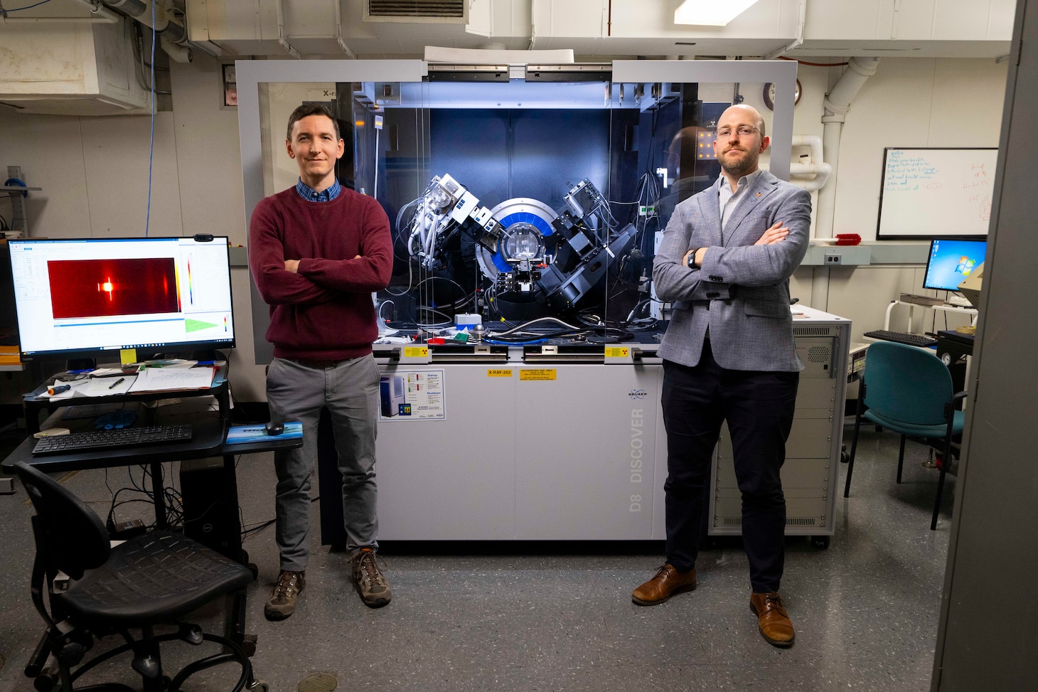 Shelby Fields (left), Ph.D., U.S. Naval Research Laboratory (NRL) materials research engineer, and Steven Bennett, Ph.D., NRL materials scientist, pose beside an x-ray diffractometer in Washington, D.C., Feb. 2, 2026. Scientists at NRL use x-ray diffraction to analyze the crystalline making of materials and compounds for a wide array of advanced Naval materials. (U.S. Navy photo by Sarah Peterson)