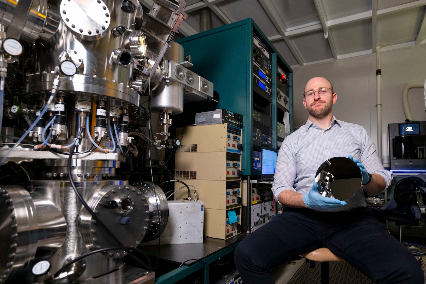 Steven Bennett, Ph.D., U.S. Naval Research Laboratory materials scientist, holds a silicon wafer in Washington, D.C., Feb. 2, 2026. Bennett uses the wafer as a substrate for physical property mapping which aids materials investigations. (U.S. Navy photo by Sarah Peterson)