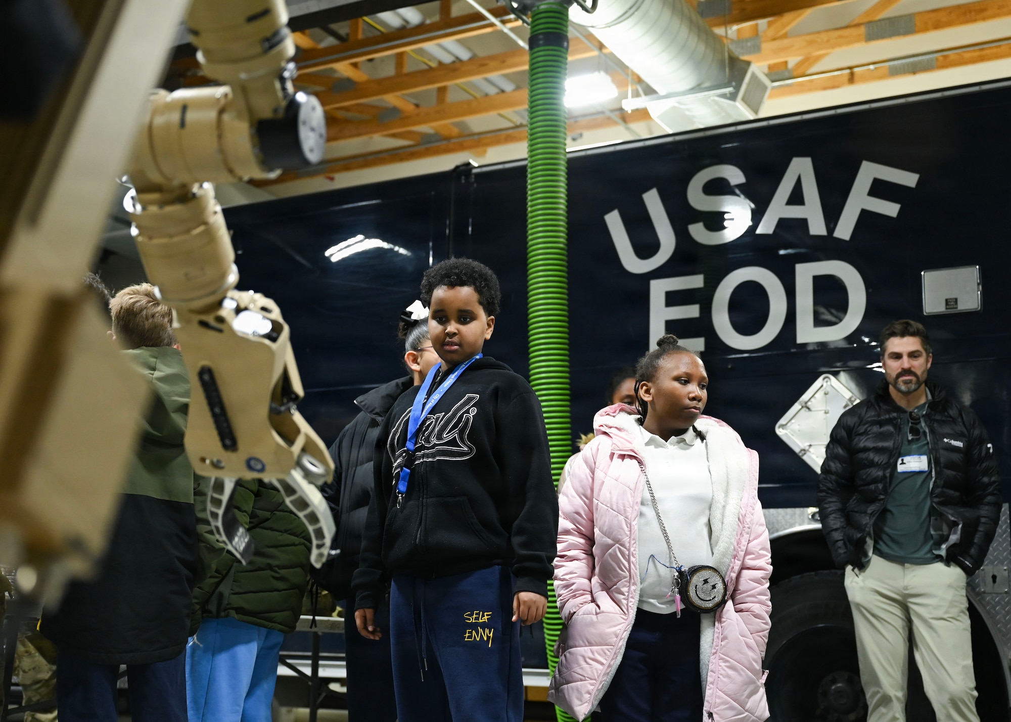 Students from Patrick Henry K-8 School watch as a U.S. Airman assigned to the 316th Civil Engineer Squadron explosive ordnance disposal flight operates a robotic system during a base tour at Joint Base Andrews, Maryland, Feb. 10, 2026. These students were able to watch EOD utilize a robotic system, view equipment, get in a truck used on missions and ask questions to gain a better understanding of jobs in the military. (U.S. Air Force photo by Staff Sgt. Aubree Owens