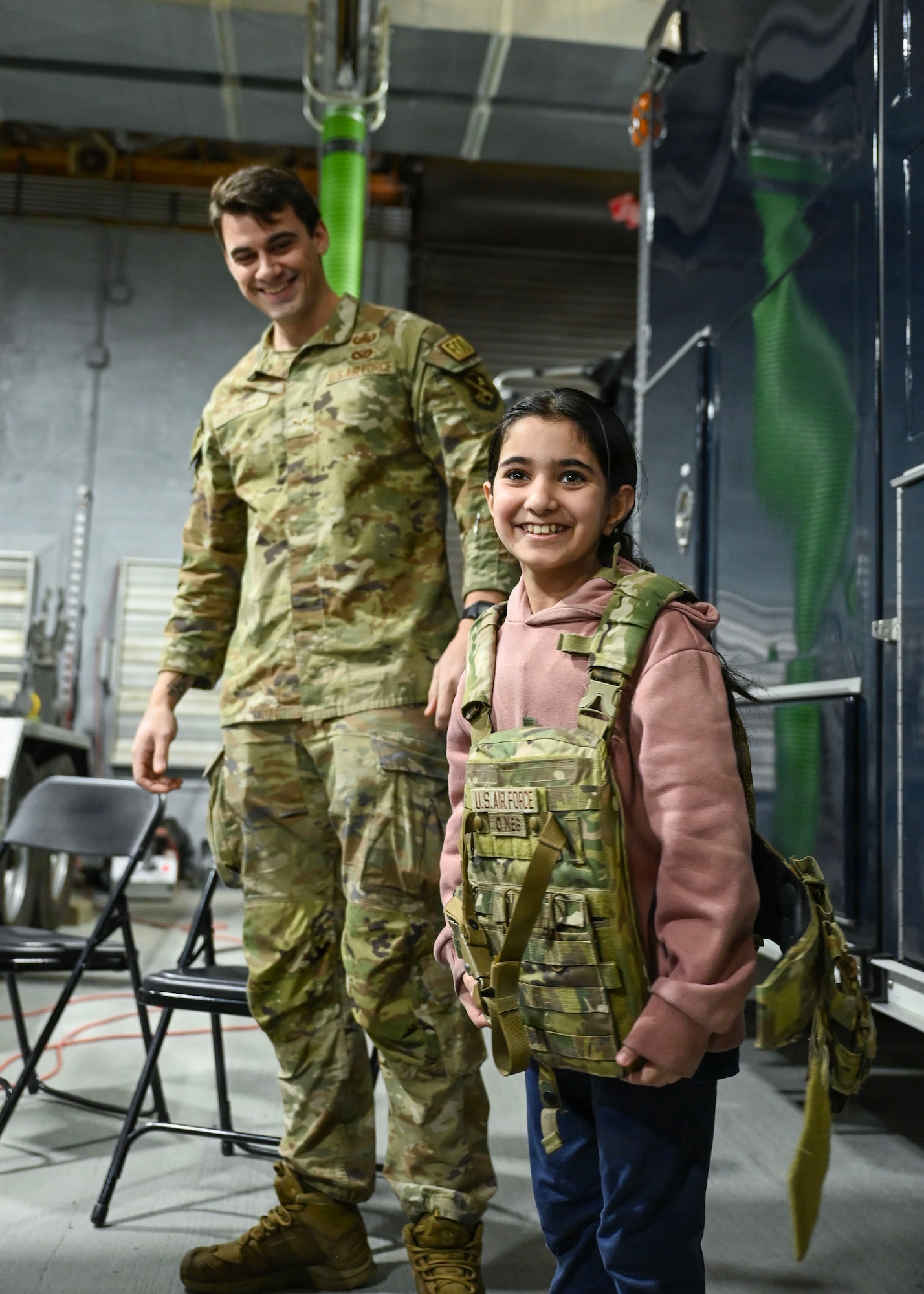 A student from Patrick Henry K-8 School tries on protective equipment with assistance from a U.S. Airmen assigned to the 316th Civil Engineer Squadron explosive ordnance disposal flight during a base tour at Joint Base Andrews, Maryland, Feb. 10, 2026. Out of 46 students who attended the tour, 45 of them had never been on a military installation before, in order to gain a better understanding of the military. (U.S. Air Force photo by Staff Sgt. Aubree Owens)