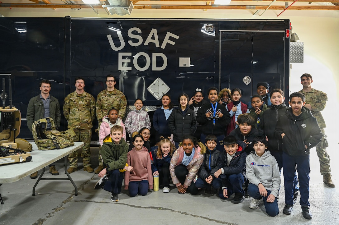 Students from Patrick Henry K-8 School take a group photos with U.S. Airmen assigned to the 316th Civil Engineer Squadron explosive ordnance disposal flight during a base tour at Joint Base Andrews, Maryland, Feb. 10, 2026. This community engagement base tour was for 46 students from a local school to gain a better understanding of the military. (U.S. Air Force photo by Staff Sgt. Aubree Owens)