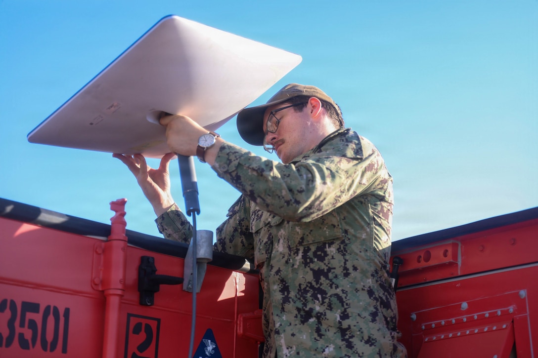 U.S. Navy Hospital Corpsman 3rd Class Nathan Wilson, a general duty nursing services corpsman assigned to the hospital ship USNS Mercy (T-AH 19), places a connectivity terminal on top of a Rapid Emplacement Medical (REM) during Exercise Steel Knight at Naval Air Station North Island in Coronado, California, Dec. 2, 2025. The Marine Corps Warfighting Laboratory/Futures Directorate examines future operating environments to generate threat-informed operating concepts and capabilities and, through experimentation, provide analytically supported recommendations to inform future force design and development activities. (U.S. Marine Corps photo by Cpl. Michael Bartman)
