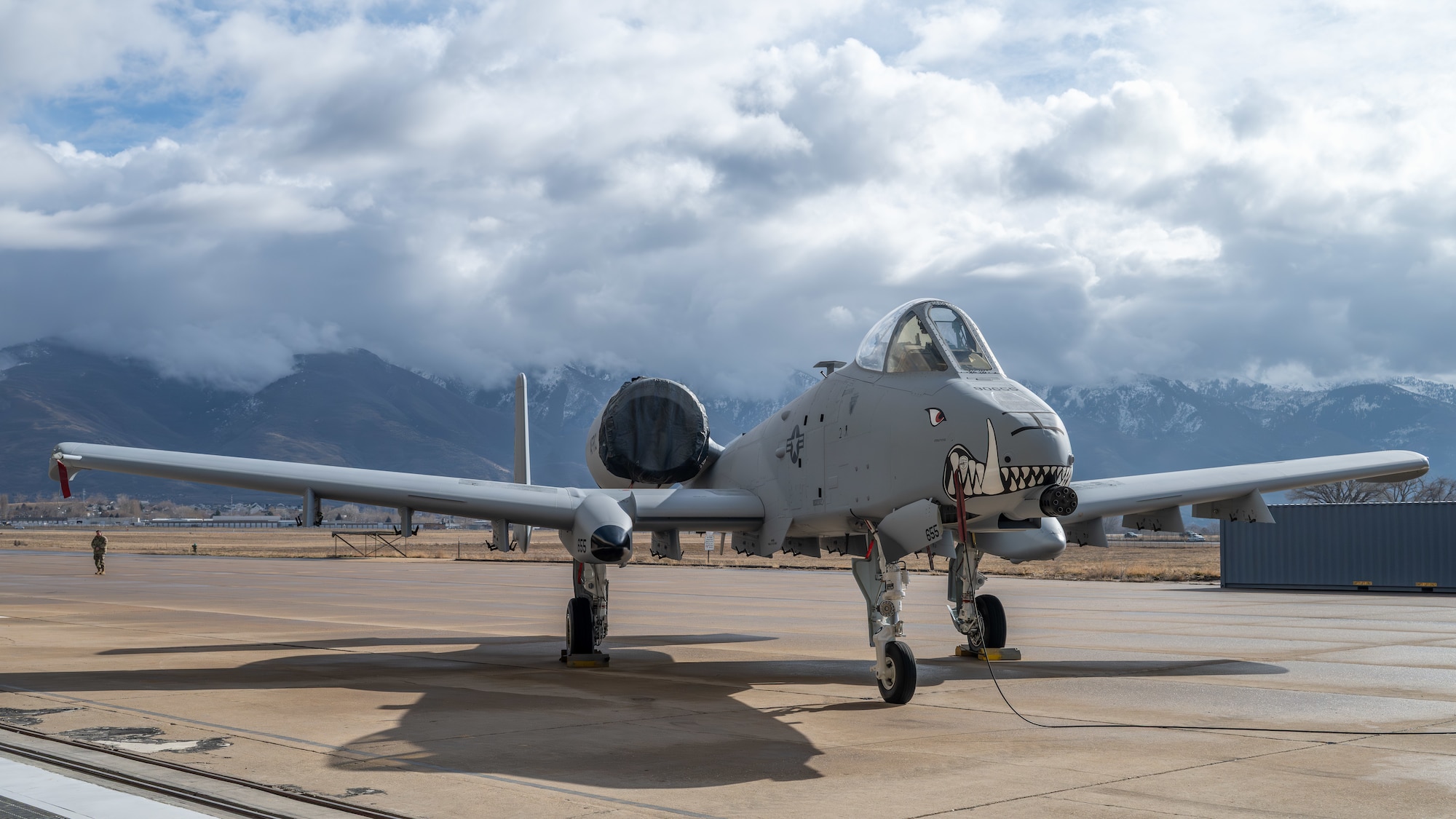 An A10 Aircraft with painted teeth on nose positioned in front of mountains
