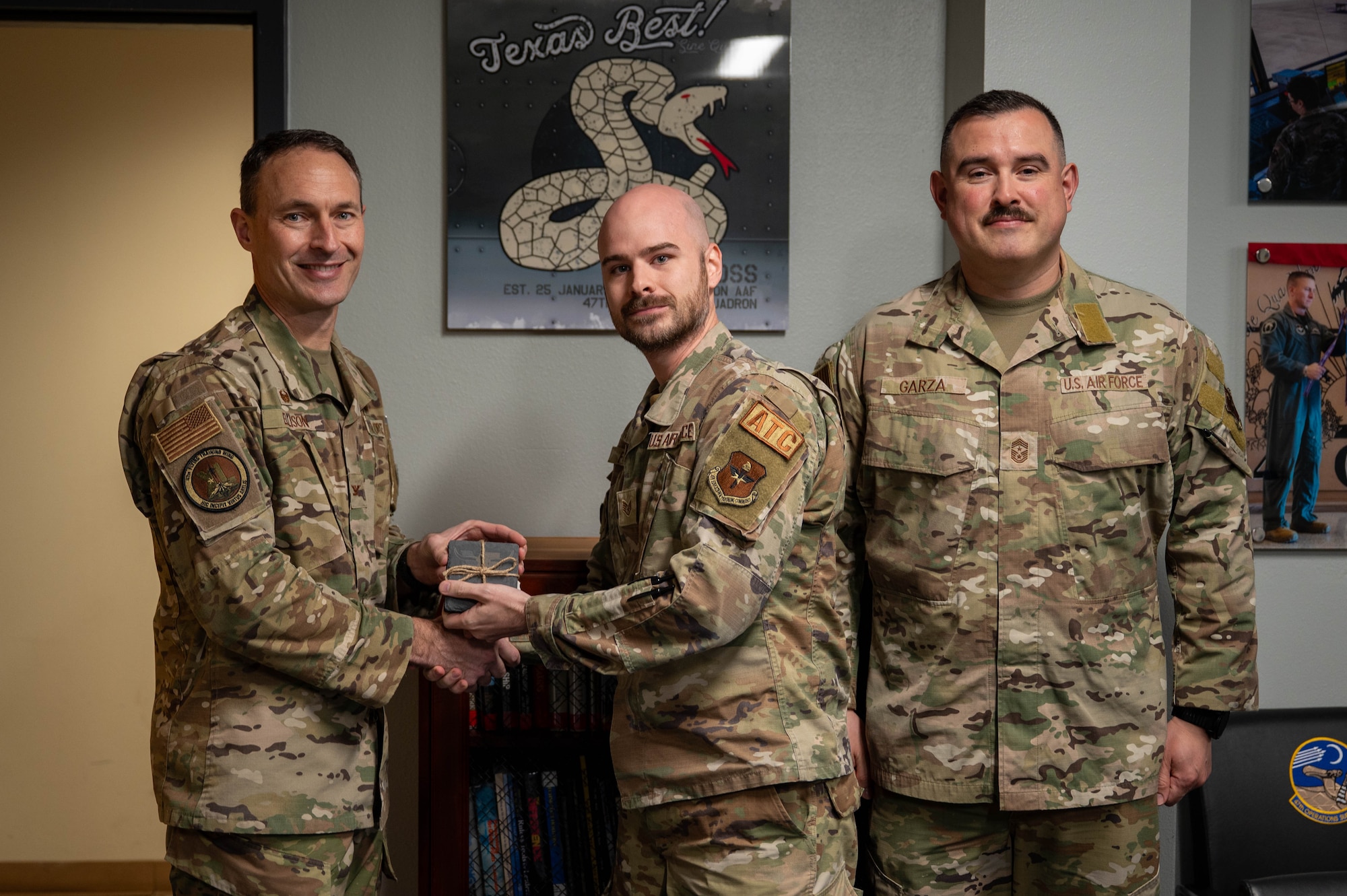 An Airman is presented an award as NCO of the fourth quarter.