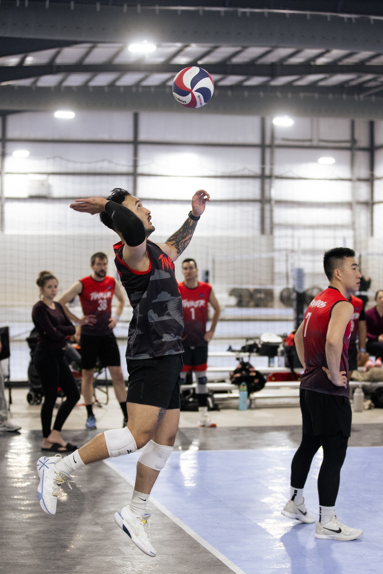 man jumps to hit volleyball