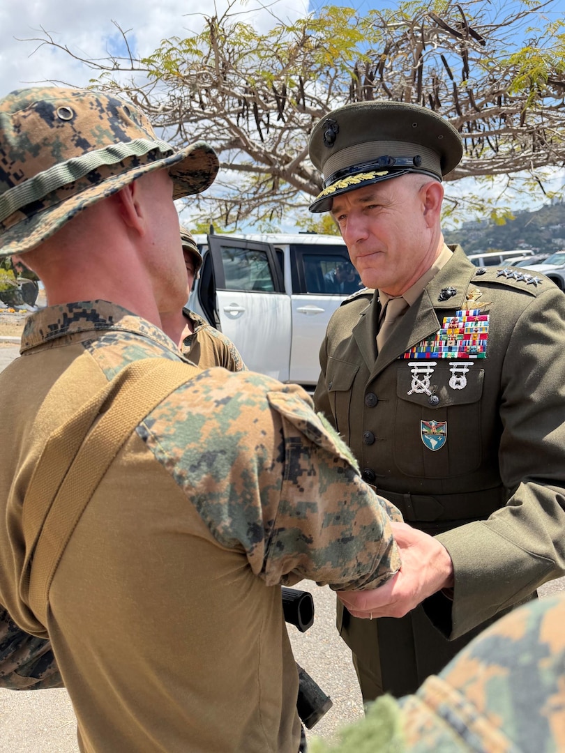 Men in military uniforms shake hands.