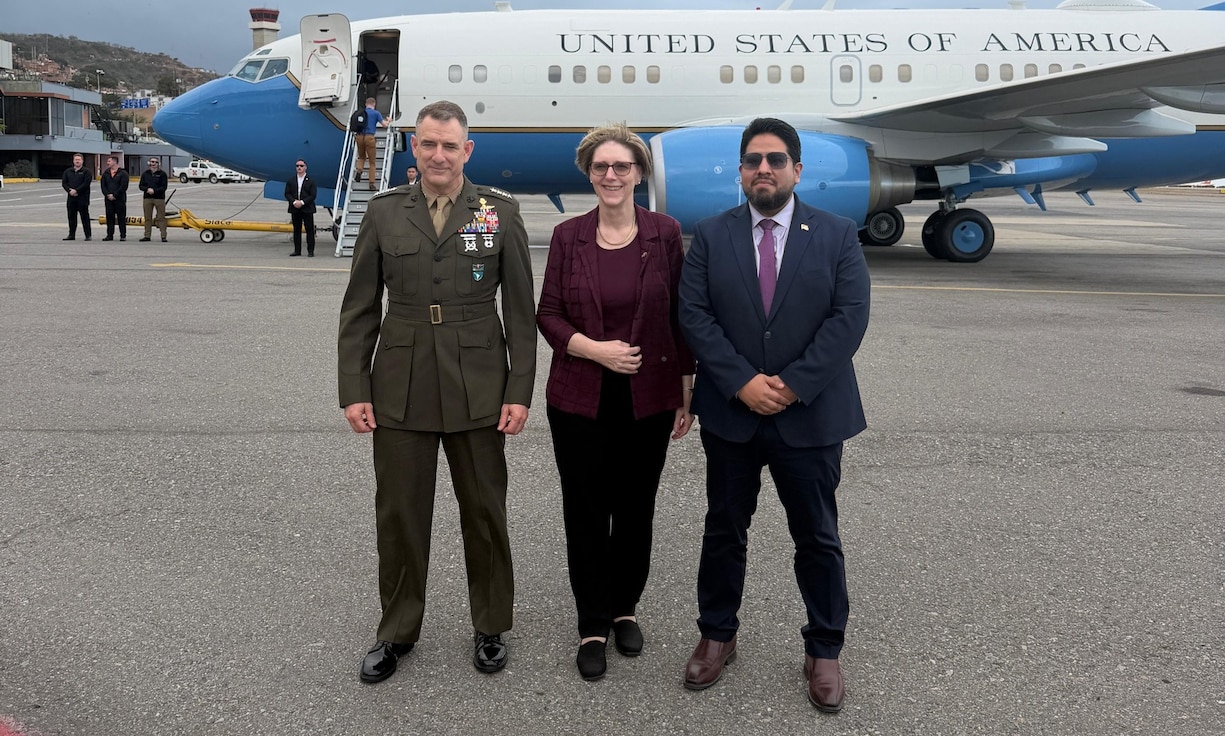 Three people pose for a photo in front of a jet.