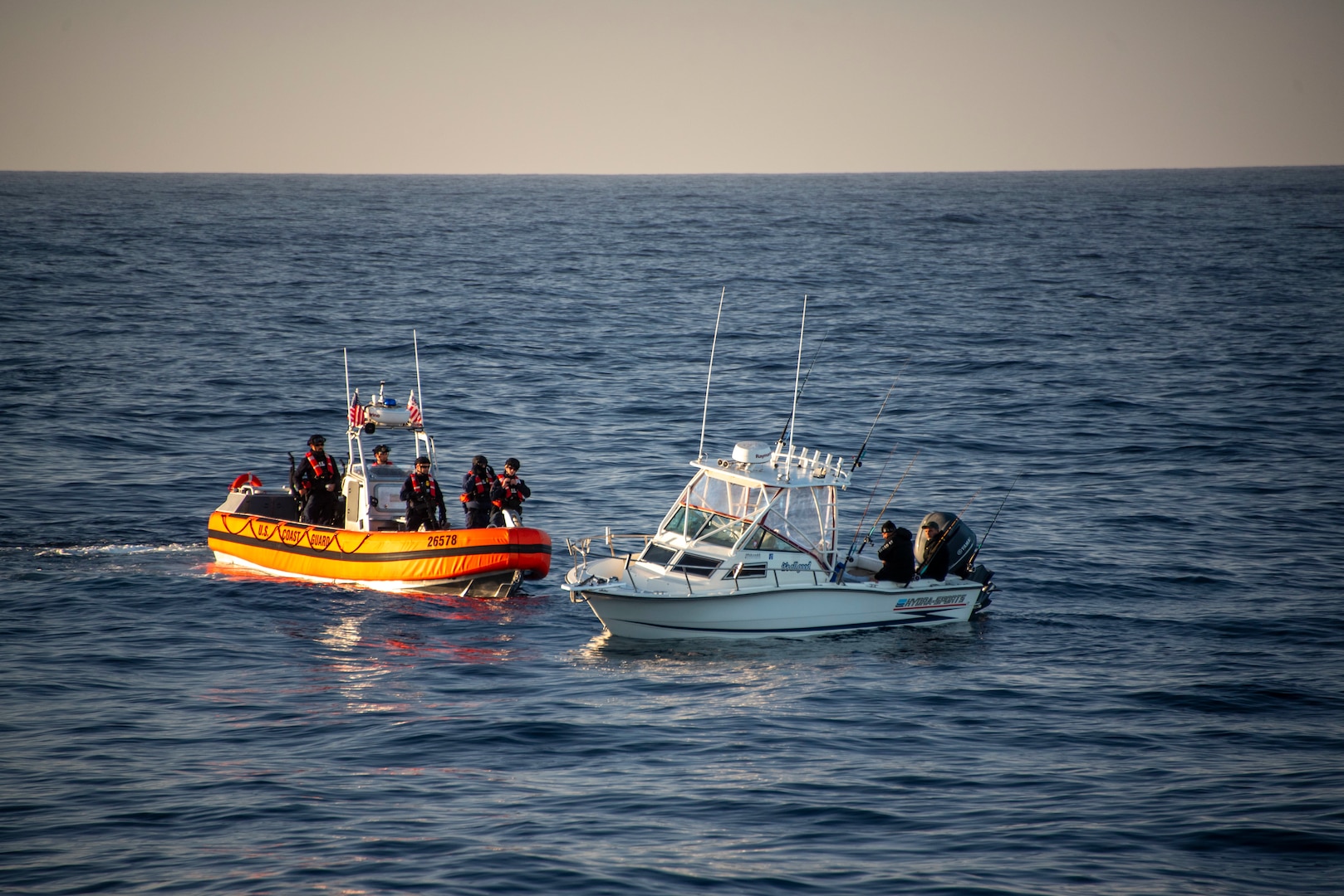 A vessel with suspected illegal migrants is approached by a Coast Guard boat.