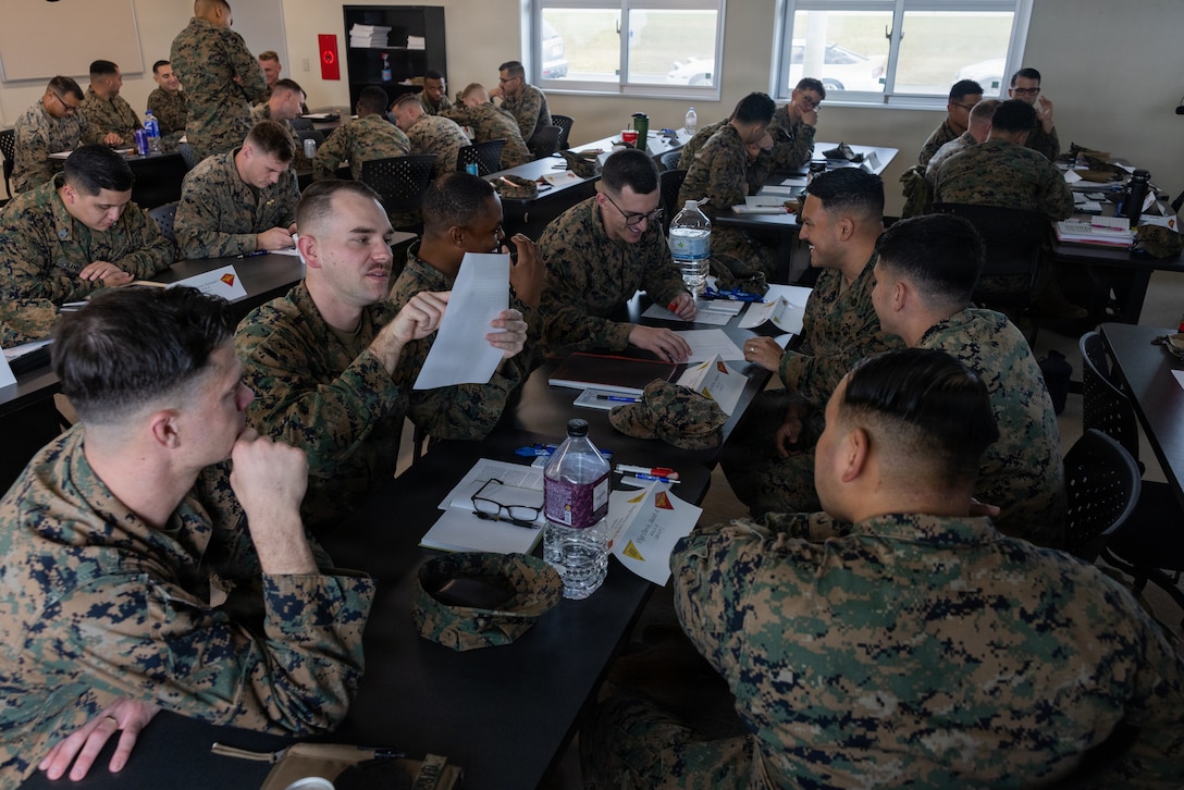 U.S. Marines with 1st Marine Aircraft Wing discuss a scenario during a staff sergeant symposium hosted by Marine Air Control Group 18 on Marine Corps Air Station Futenma, Okinawa, Japan, Jan. 13, 2026. Staff sergeants with 1st MAW gathered to receive professional development classes focused on strengthening leadership skills and reinforcing their roles as mentors to Marines. (U.S. Marine Corps photo by Lance Cpl. Carlos Paz-Sosa)