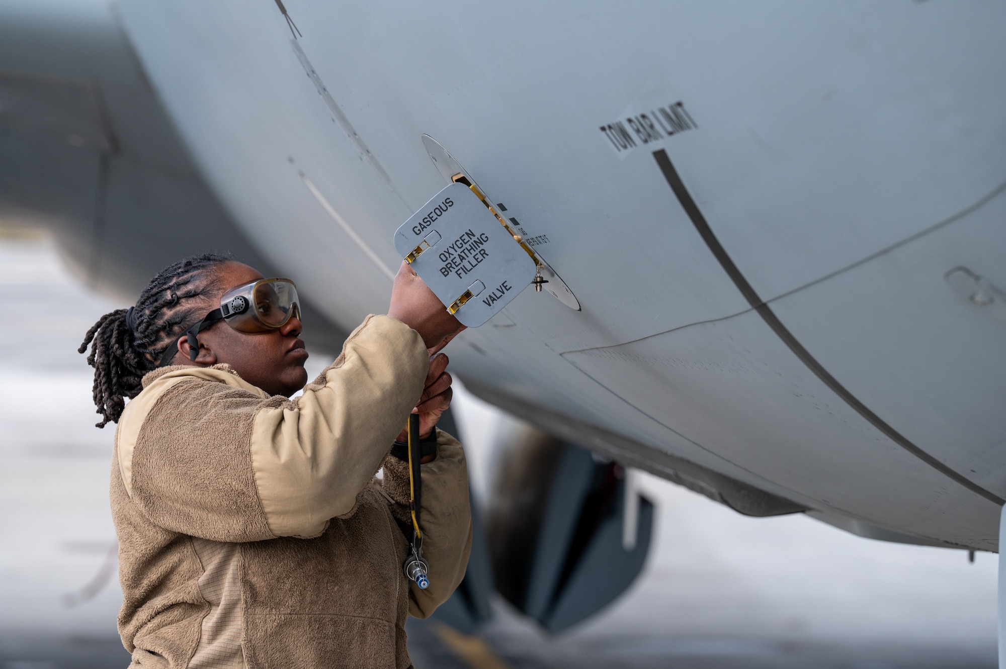 A military member connects a hose.