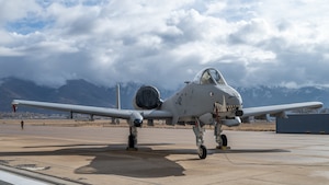 An A10 Aircraft with painted teeth on nose positioned in front of mountains