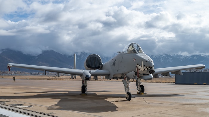 An A10 Aircraft with painted teeth on nose positioned in front of mountains