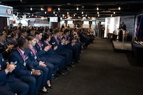 A seated audience claps at an event.