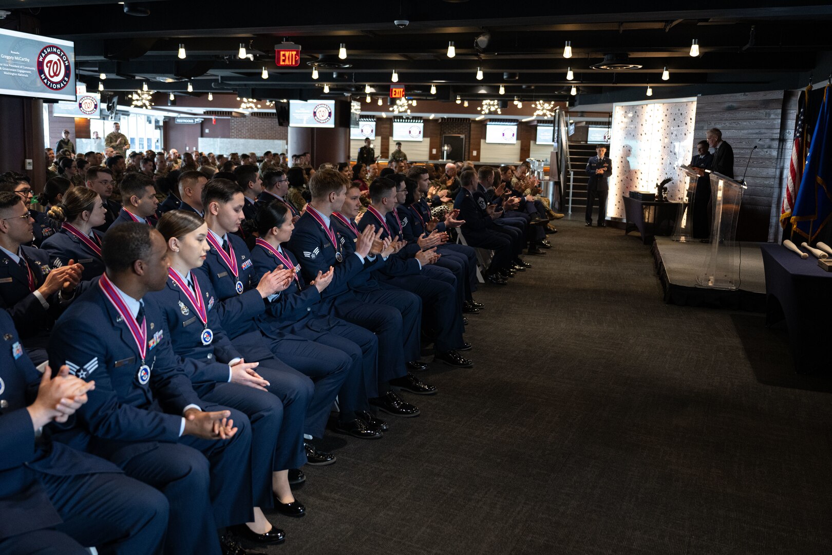 A seated audience claps at an event.