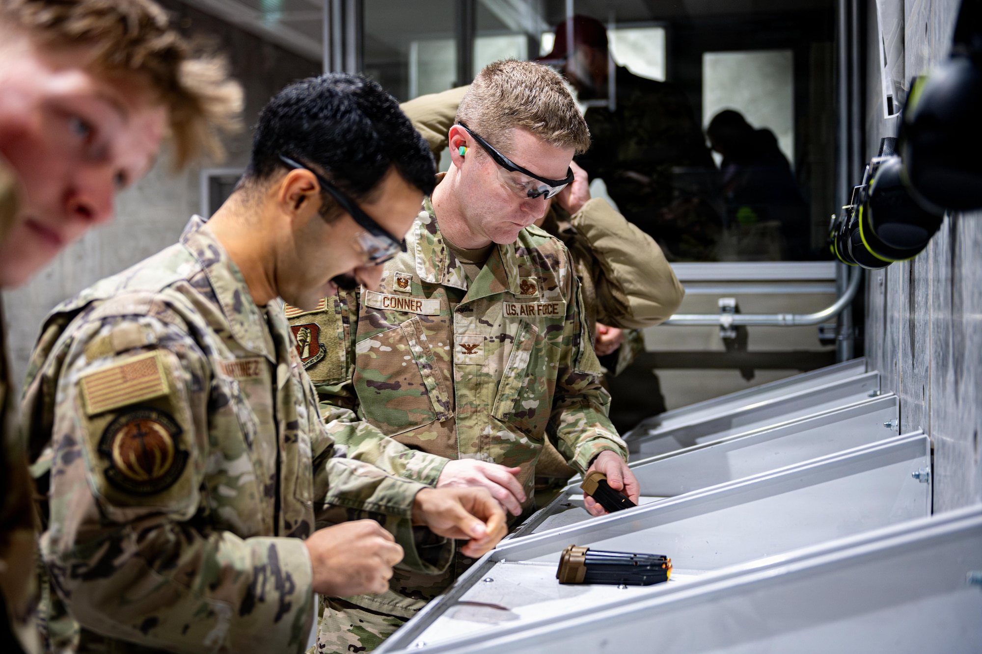 U.S. Airmen assigned to the 35th Fighter Wing load M18 service pistol magazines during a competition in honor of Presidents Day.