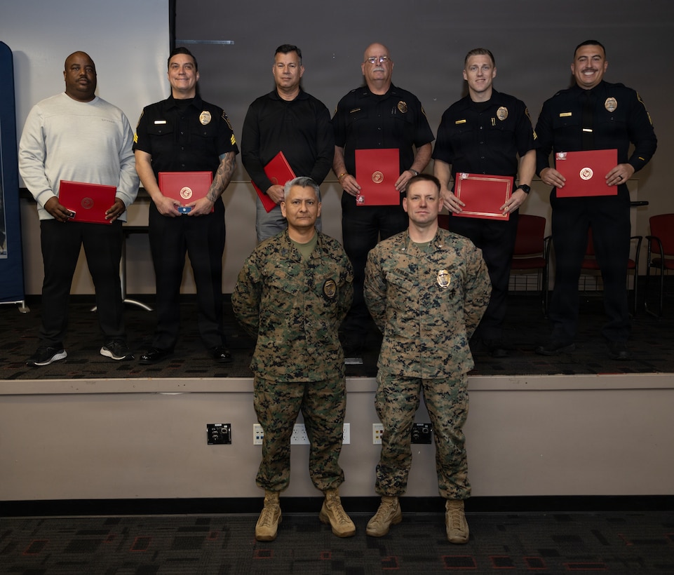 U.S. Marine Corps Master Gunnery Sgt. Lee, bottom left, provost sergeant, Provost Marshal’s Office, Marine Corps Base Camp Pendleton, and Lt. Col. Fowler, bottom right, provost marshal, Provost Marshal’s Office, MCB Camp Pendleton, stand for a photo with officers with the Marine Corps Law Enforcement Program during a MCLEP Officer and Civilian Employee Awards Ceremony at MCB Camp Pendleton, Calif., Feb. 17, 2026. The ceremony was held to award the outstanding contributions and commitment of MCLEP officers and recognize civilian employees for their federal length-of-service accomplishments. (U.S. Marine Corps photo by Sgt. Buck)