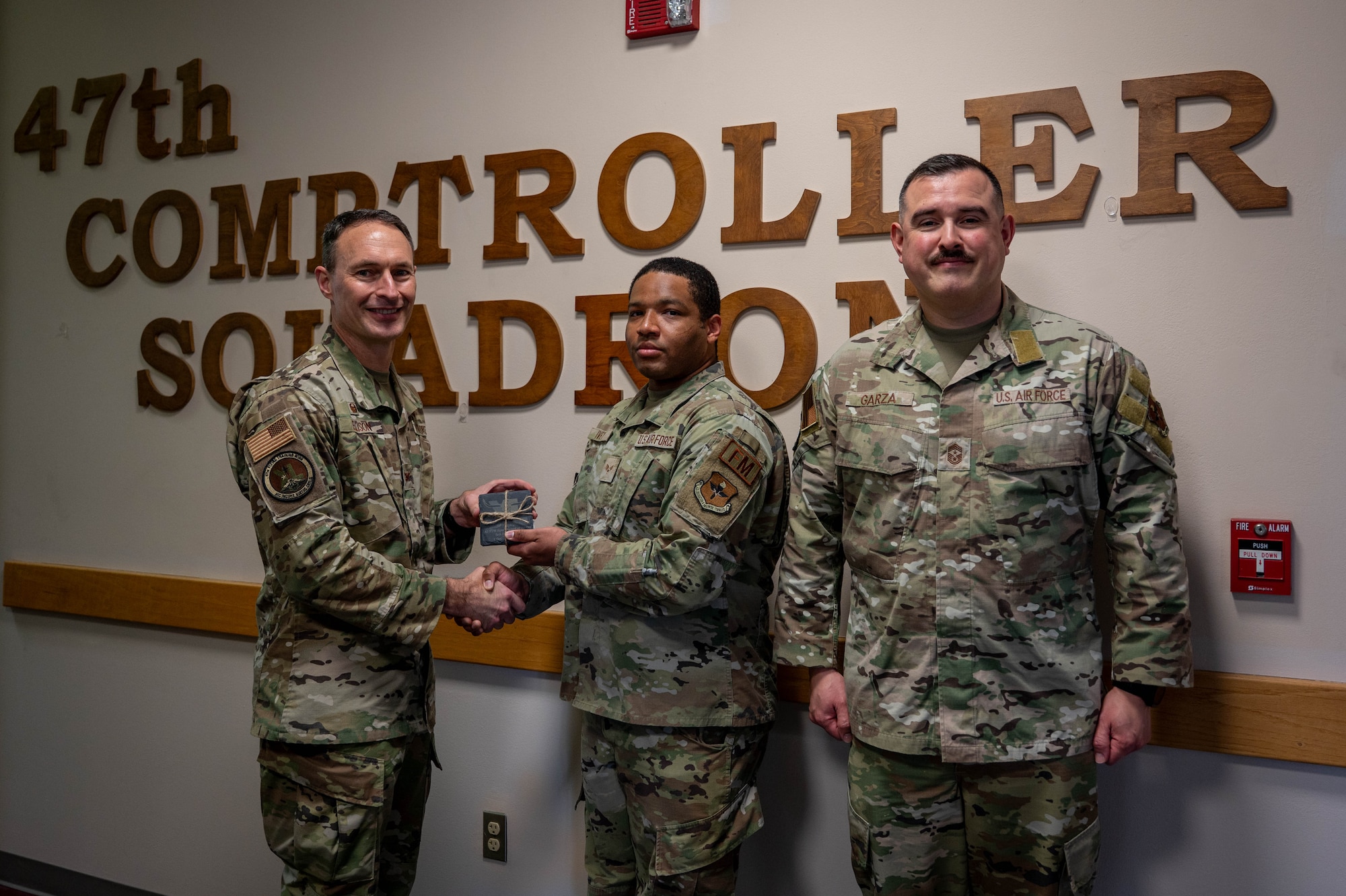 An Airman is presented an award as honor guardsman of the fourth quarter.