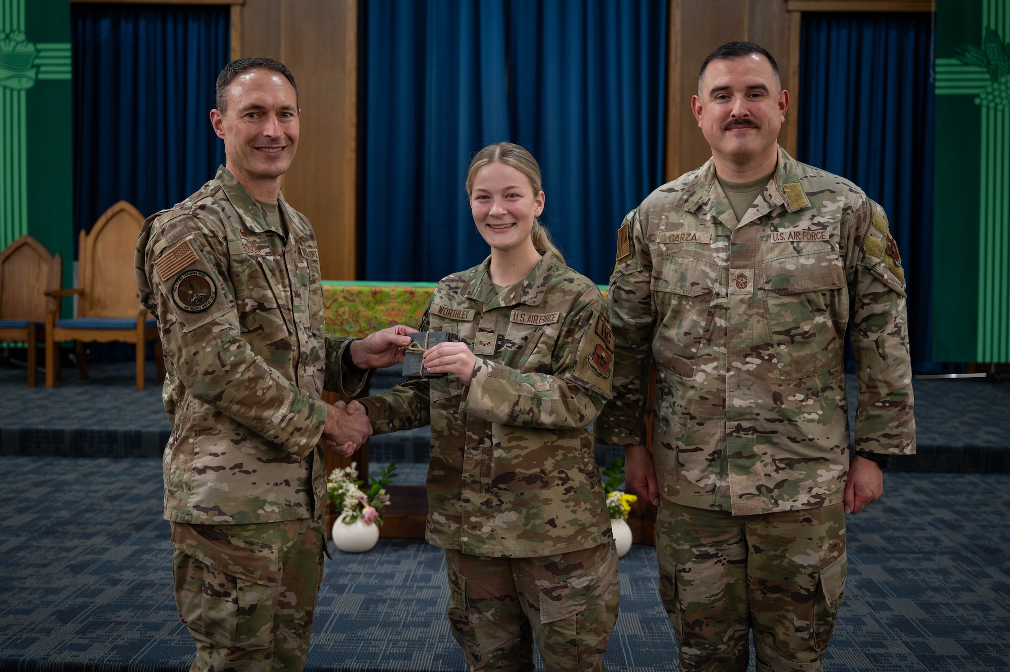 An Airman is presented an award as Airman of the fourth quarter.