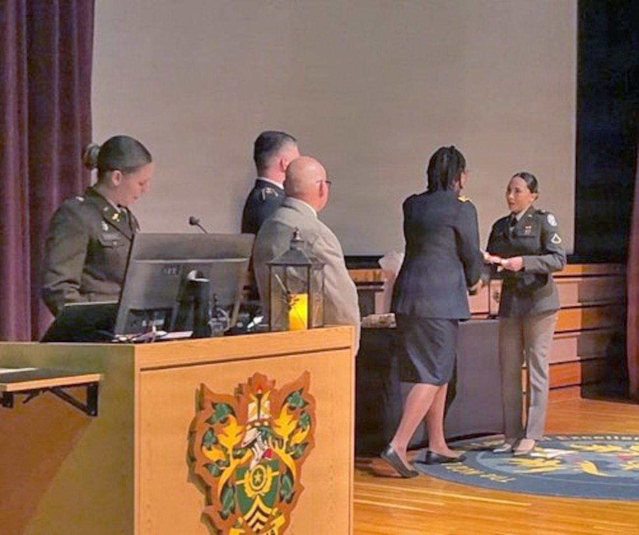 Pfc. Paulina Cazarez Curiel (far right), honor graduate, receives her diploma during a Practical Nurse Course graduation ceremony held at the NCO Leadership Center of Excellence.