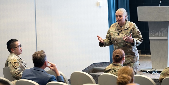 A female Airman speaks to a crowd.