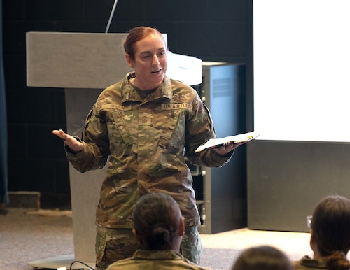 A female Airman speaks to a crowd.