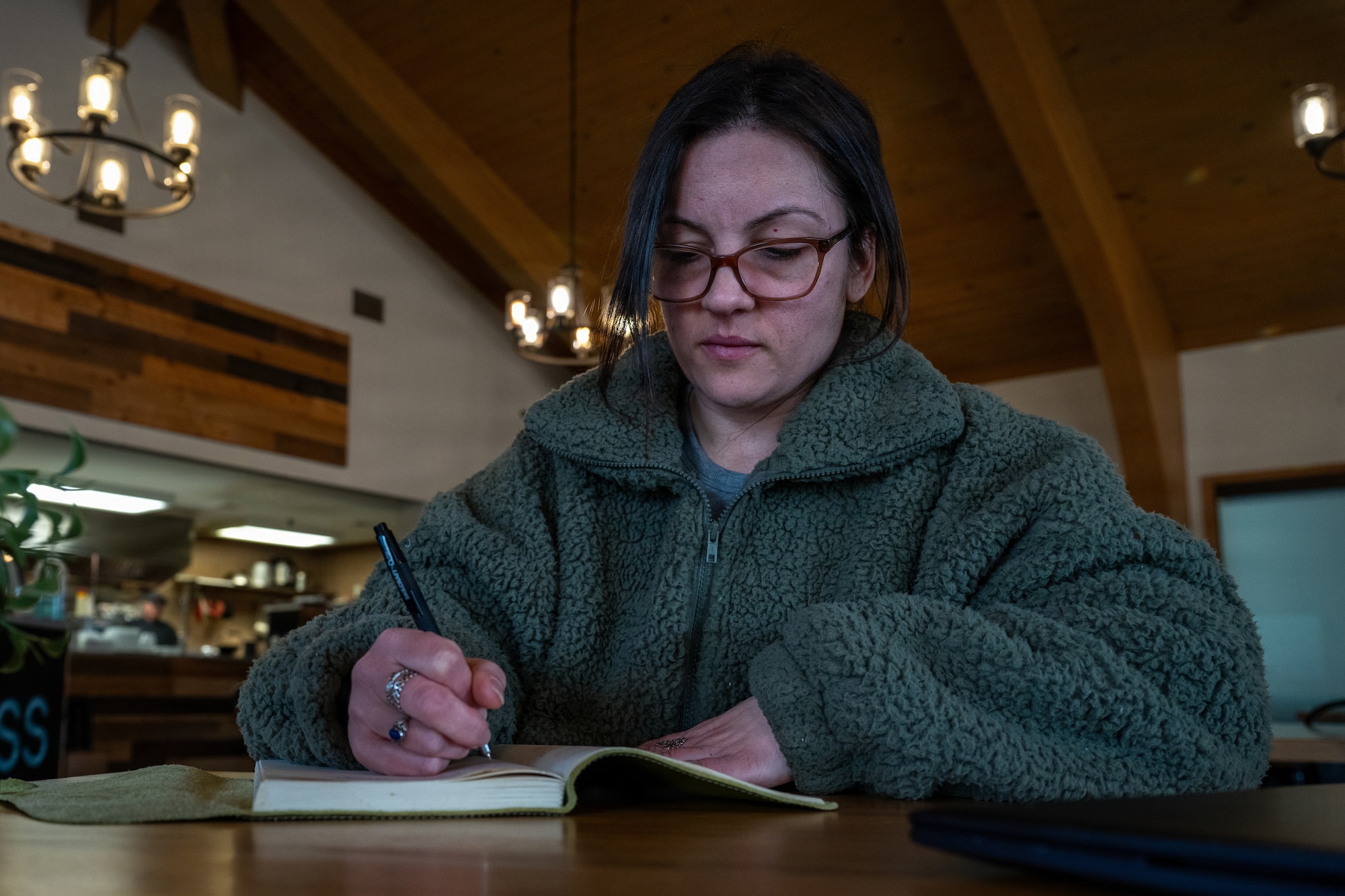 U.S. Air Force Staff Sgt. Alison Gandulla, 4th Contracting Squadron contract specialist, composes poetry in a journal at Seymour Johnson Air Force Base, North Carolina, Feb. 12, 2026. Gandulla uses personal experiences to create poetry that cultivates resilience and mental fortitude. (U.S. Air Force photo by Airman 1st Class Rebecca Tierney)