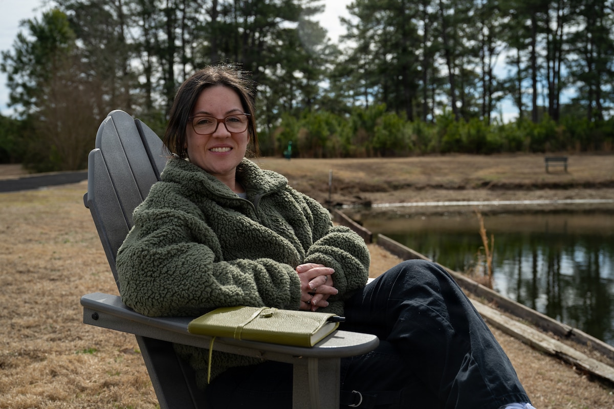 U.S. Air Force Staff Sgt. Alison Gandulla, 4th Contracting Squadron contract specialist, poses for an environmental portrait at Seymour Johnson Air Force Base, North Carolina, March 4, 2025. Gandulla uses personal experiences to create poetry that cultivates resilience and mental fortitude.(U.S. Air Force photo by Airman 1st Class Rebecca Tierney)