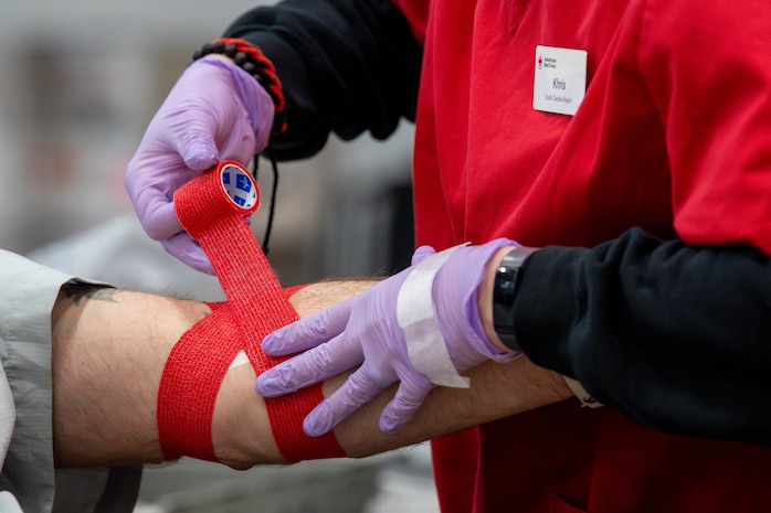 A photo of a man being wrapped with gauze after donating blood.