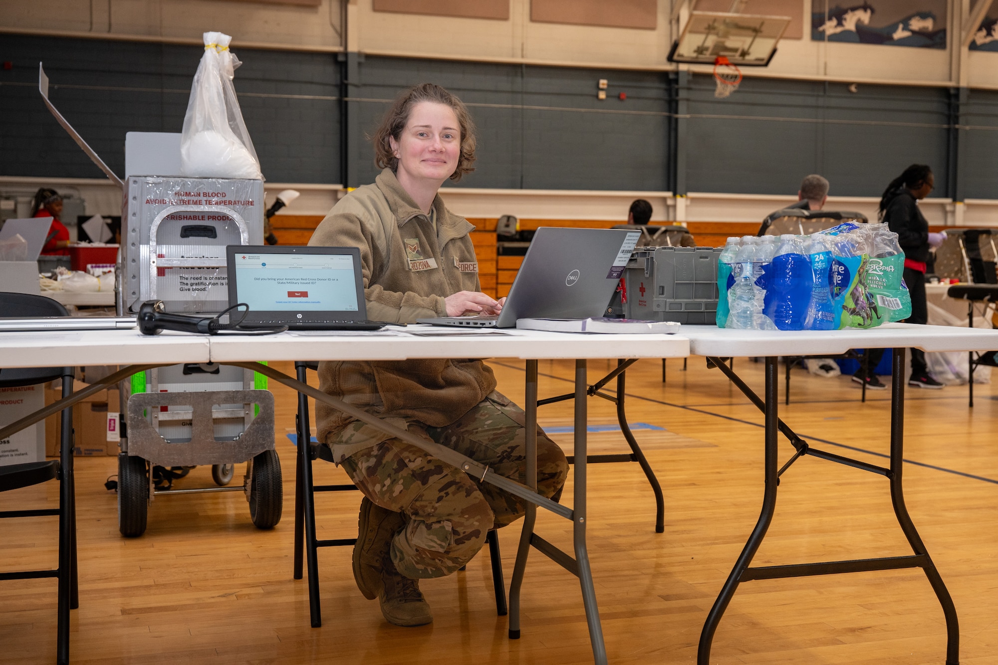 A photo of a woman sitting at the front desk for a blood drive.