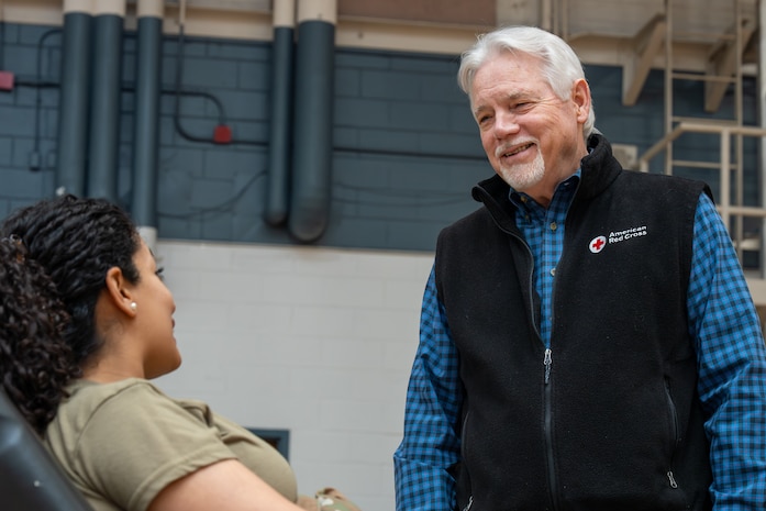 A photo of a man and a woman conversing during a blood drive.