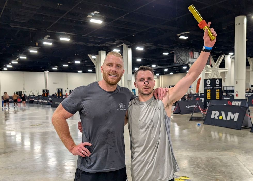 two men stand together after fitness competition