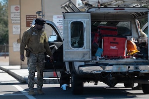 U.S. Air Force Airman 1st Class Jean-Pierre Tshamala, 6th Security Forces Squadron entry controller, inspects a vehicle at MacDill Air Force Base, Florida, Feb. 9, 2026. The 6th SFS implemented a new process at Tanker Way Gate to streamline installation access for delivery and commercial vehicles, including household goods shipments. (U.S. Air Force photo by Airman 1st Class Autumn Lindor)