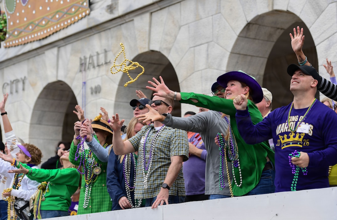 People reach for beads from a reviewing stand.