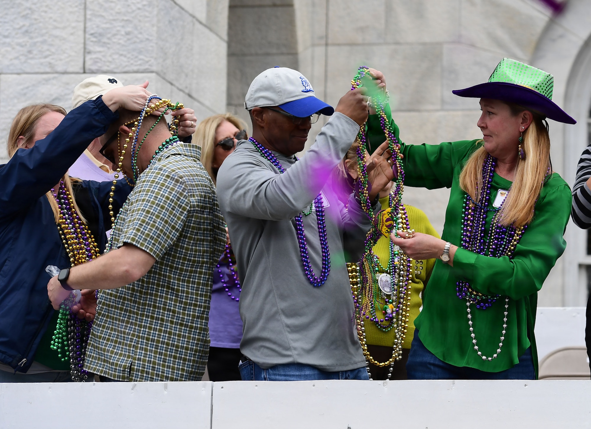 People place beads around each others' necks.