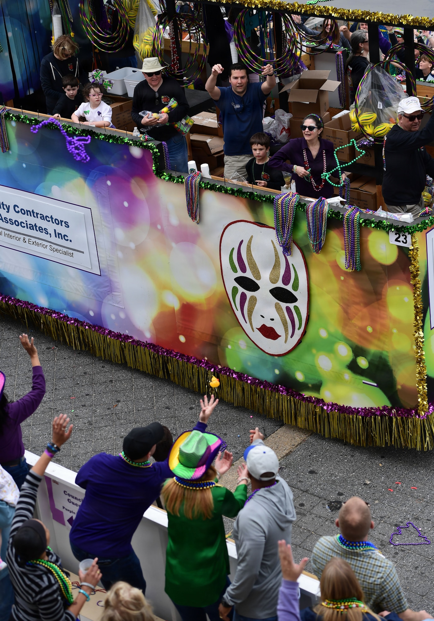 People throw beads to parade goers from a parade float.