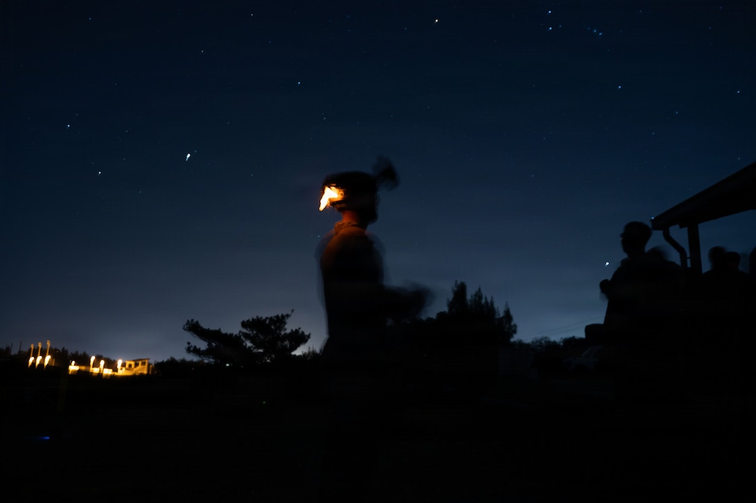 A U.S. Marine with 12th Littoral Combat Team, 12th Marine Littoral Regiment, 3rd Marine Division, prepares to execute night fire-team attacks on Camp Hansen, Okinawa, Japan, Jan. 15, 2026. The training refined weapon system and tactical proficiency, strengthening overall combat readiness and preparing 12th LCT for future operational requirements. (U.S. Marine Corps photo by Lance Cpl. Camila Garibay)