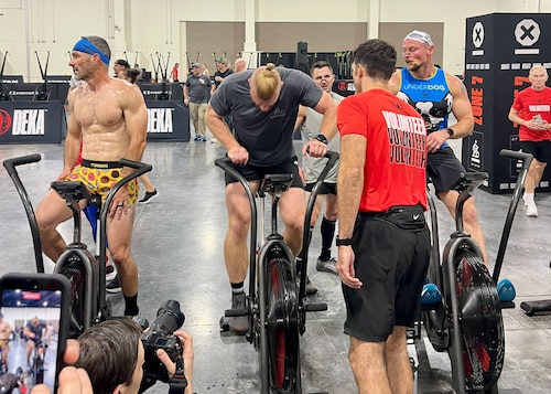 man rides air bike during fitness competition