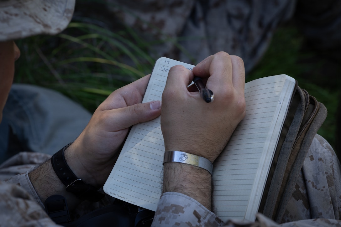 A U.S. Marine with 1st Battalion, 25th Marine Regiment, writes down information in a notebook during an Intermediate Location (ILOC) event held at Camp Pendleton, California, Feb. 9, 2026. ILOC is a pre-deployment event to ensure readiness, emphasizing small-unit leadership roles and responsibilities. (U.S. Marine Corps photo by Lance Cpl. Claire Cheney)
