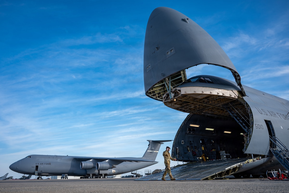 Airman 1st Class Alexander Smith, 22nd Airlift Squadron C-5M Super Galaxy flight engineer, assists in loading equipment on a C-5M during exercise Reef Runner on the flightline at Travis Air Force Base, Calif., Feb. 1, 2026. The exercise was a proof of concept to demonstrate the capability of a C-5M to transport an 821st Contingency Response Squadron assessment team from Travis AFB to Guam without aerial refueling and while maintaining full-role capability. (U.S. Air Force photo by Senior Airman Robert Nichols)