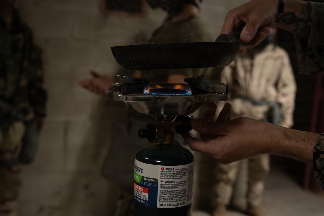 U.S. Marine Corps Sgt. Anthony Yordi, a chemical, biological, radiological and nuclear defense specialist with 2nd Battalion, 1st Marine Regiment, turns on a burner plate during an Intermediate Location (ILOC) event held at Camp Pendleton, California, Feb. 9, 2026. ILOC is a pre-deployment event to ensure readiness, emphasizing small-unit leadership roles and responsibilities. (U.S. Marine Corps photo by Lance Cpl. Claire Cheney)