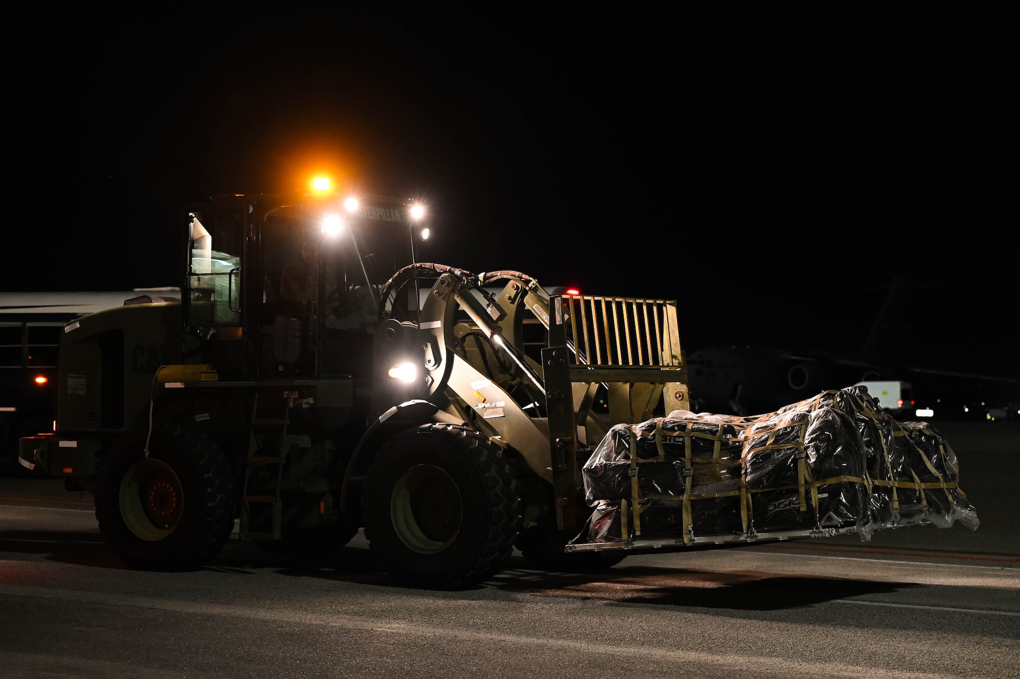 U.S. Air Force Airman 1st Class Matthew Delaney, 437th Airlift Wing air transportation specialist, operates a forklift carrying a pallet of luggage returning from Operation Palmetto Reach, a part of Combat Readiness Exercise 2026, at Joint Base Charleston.