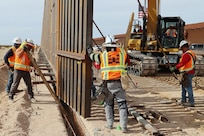 The U.S. Army Corps of Engineers contractors dig trenches and install border panels at the west end of the BMGR-1 project site Jan. 28 near Yuma, Arizona. USACE is replacing permanent border barriers along the southern border of the U.S. at the direction of the U.S. Army by the Secretary of War, in response to the presidential national emergency declaration dated Jan. 20, 2025, authorizing the use of Section 2803 of Title 10, U.S. Code. (No one in this image crossed the international border) (Photo by Robert DeDeaux USACE PAO).